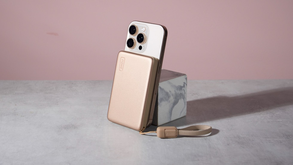 The Iniu SnapGo Air 10000mAh Power Bank attached to an iPhone 16 Pro leaning against a marble block.