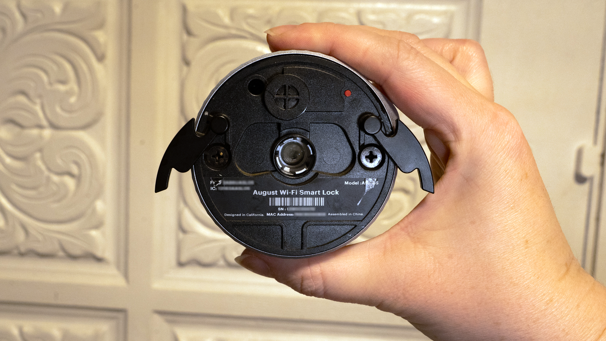 Person's hand holding smart lock ready to be installed