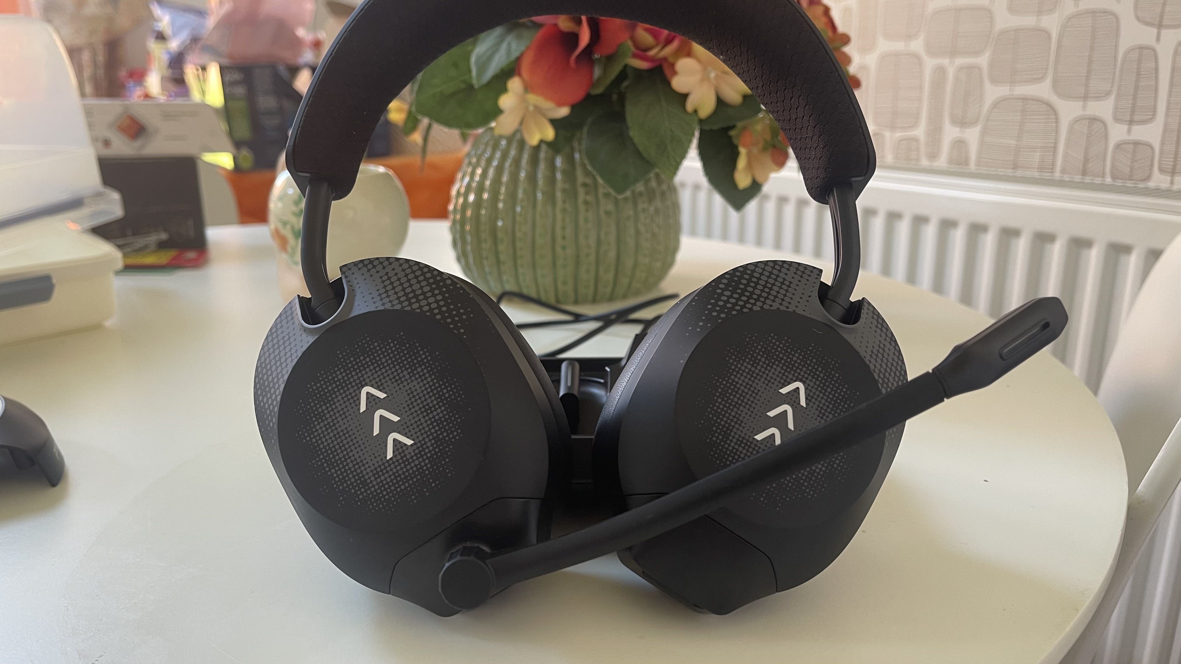 The RIG R8 PRO HS gaming headset on its base station sitting on a light coloured table