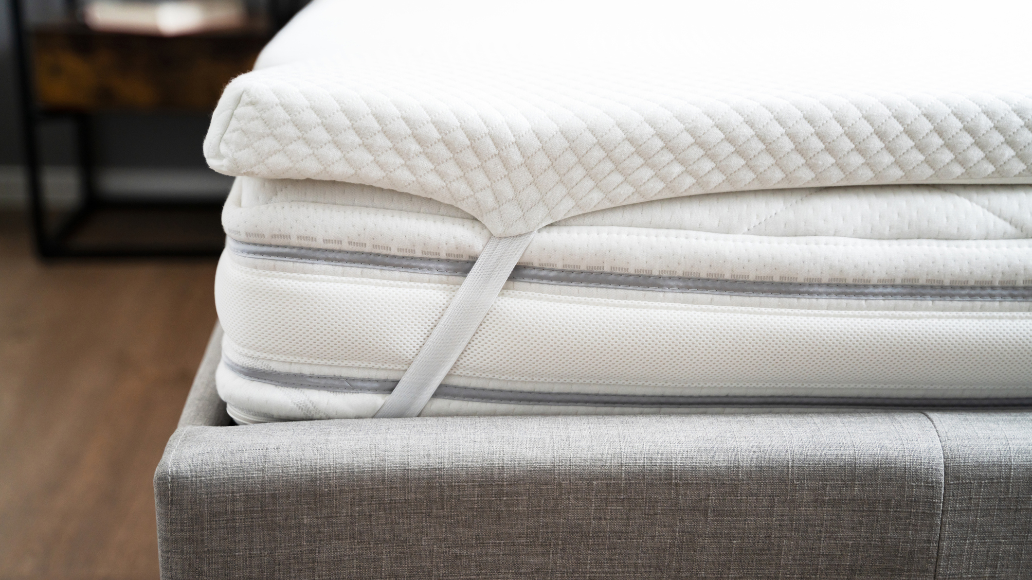 Image shows memory foam mattress on a grey fabric bed base and with a topper
