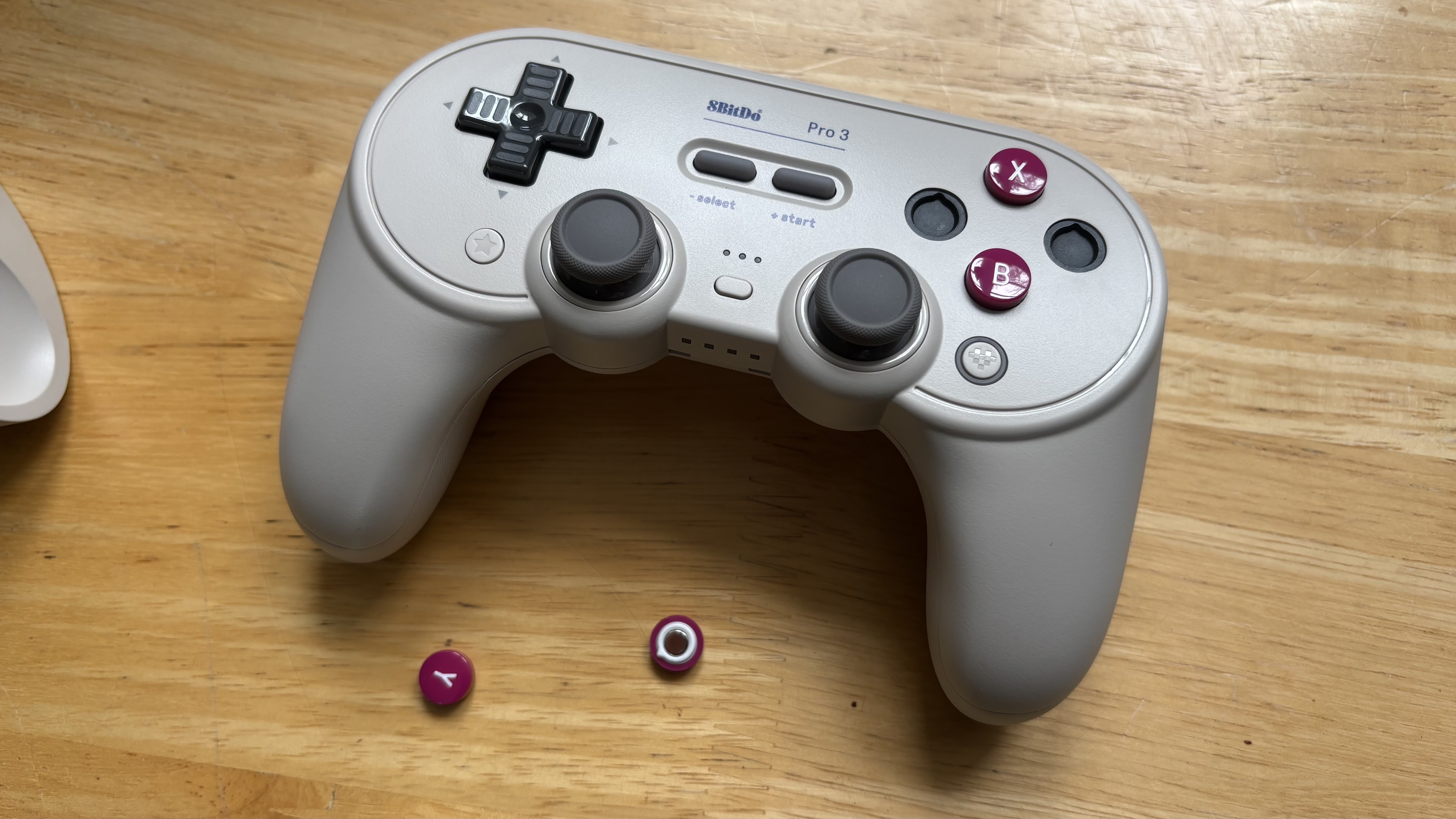 The 8BitDo Pro 3 controller photographed on a wooden table.