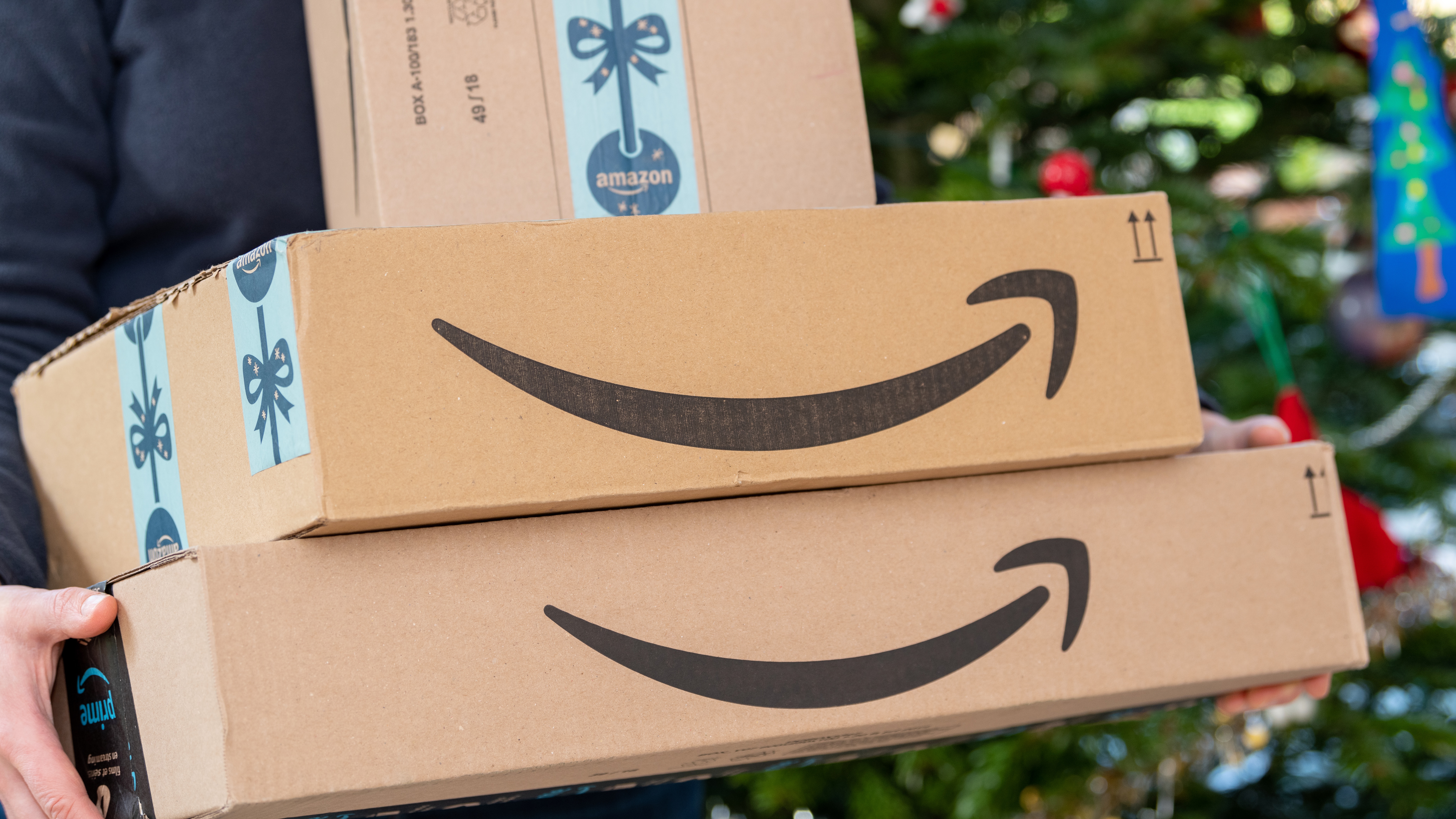 Person carrying Amazon boxes