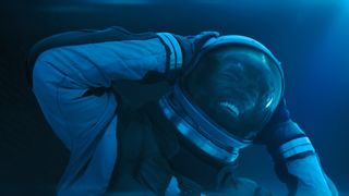 A man grimacing in pain in a spacesuit