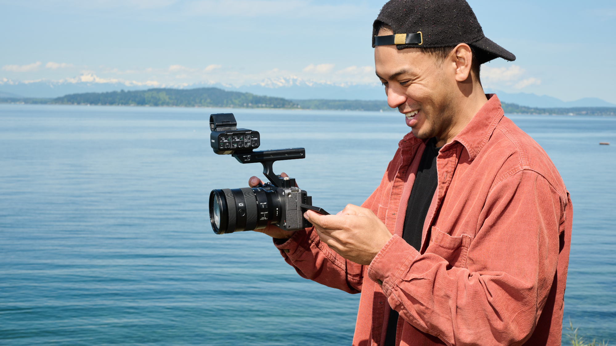 Man holding a camera in front of a sea