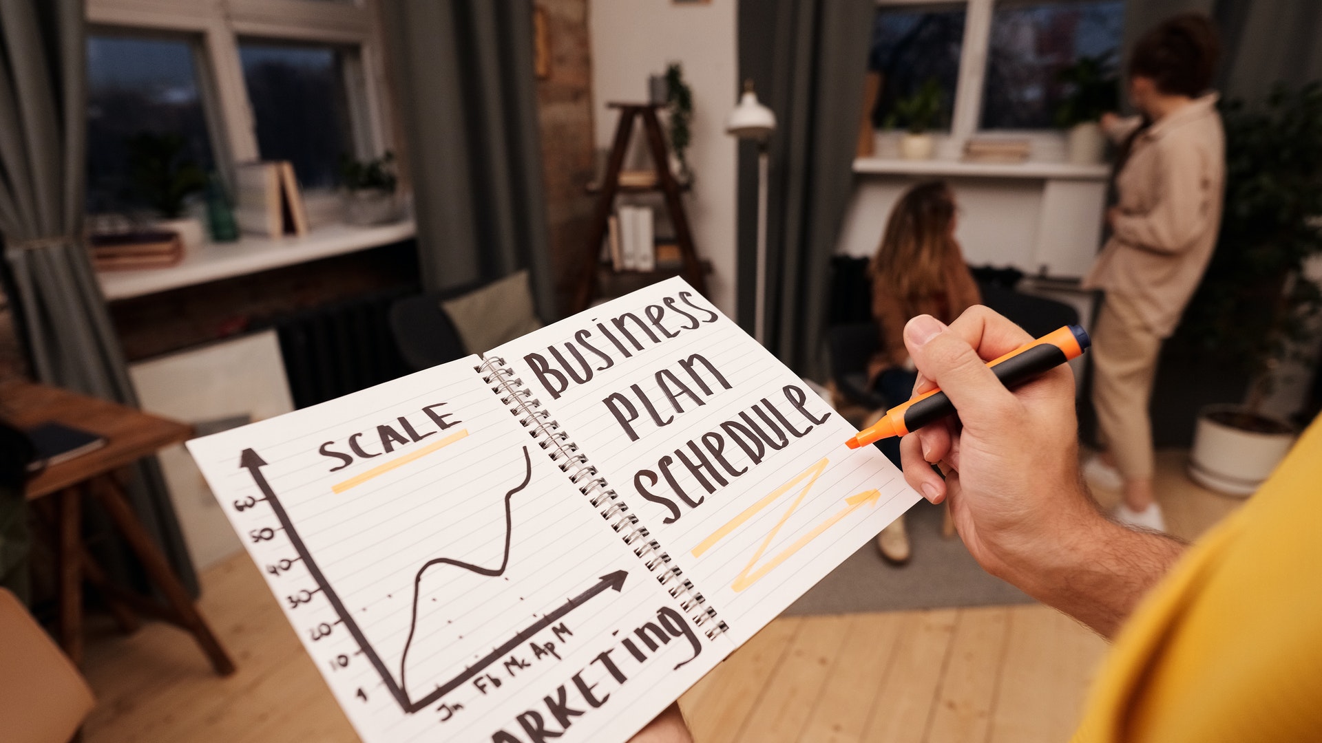 person writing business plan schedule on notepad