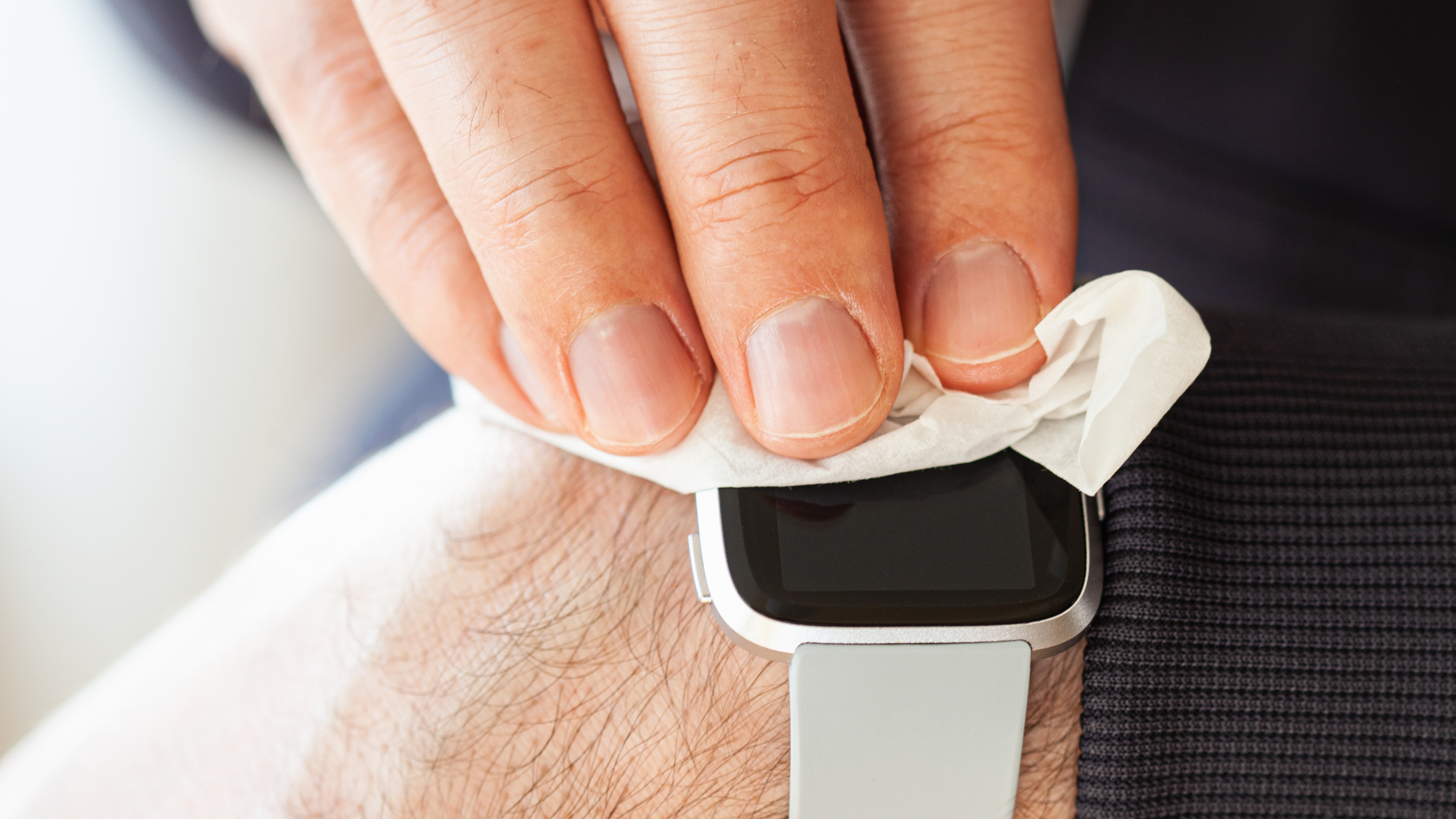 Man wiping Fitbit lens with a cloth