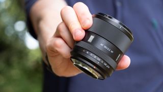 Viltrox AF 90mm f/2.2 EVO lens held by tech journalist and pro photographer Tim Coleman