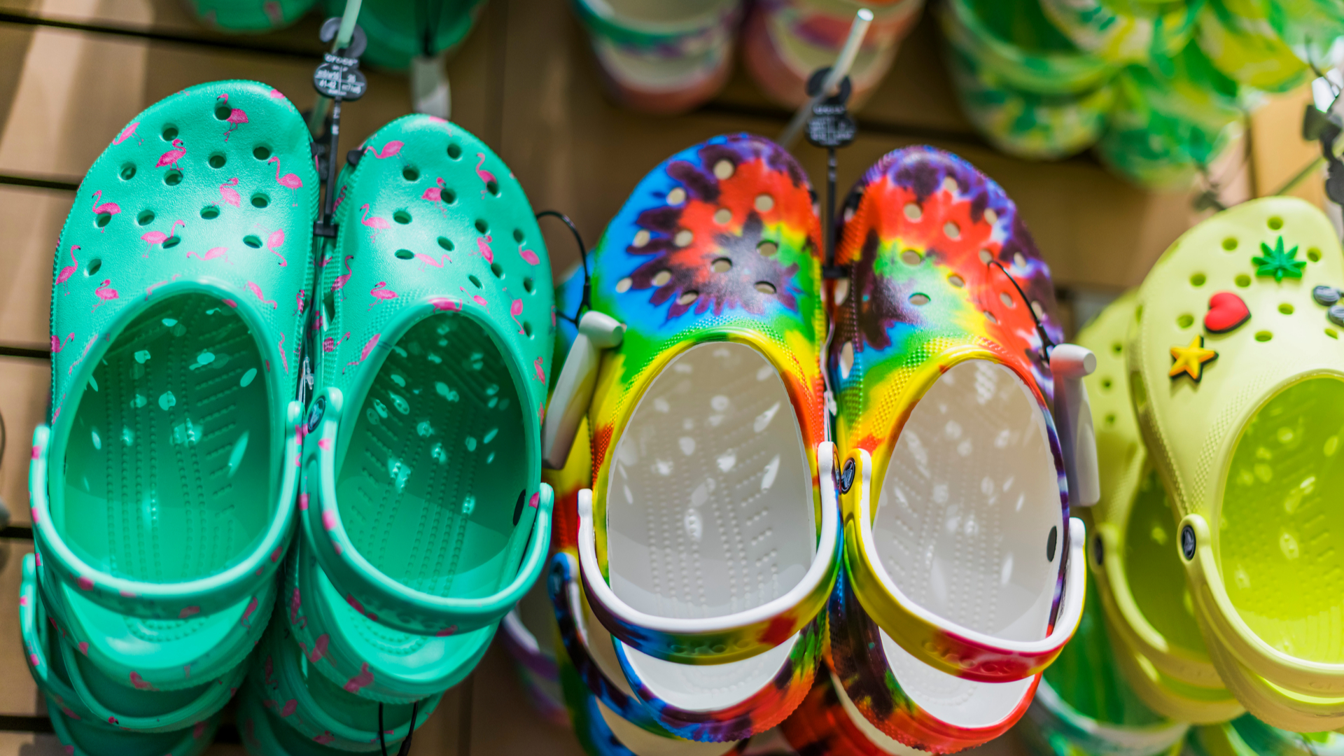 A wall of colorful Croc shoes being displayed in a store