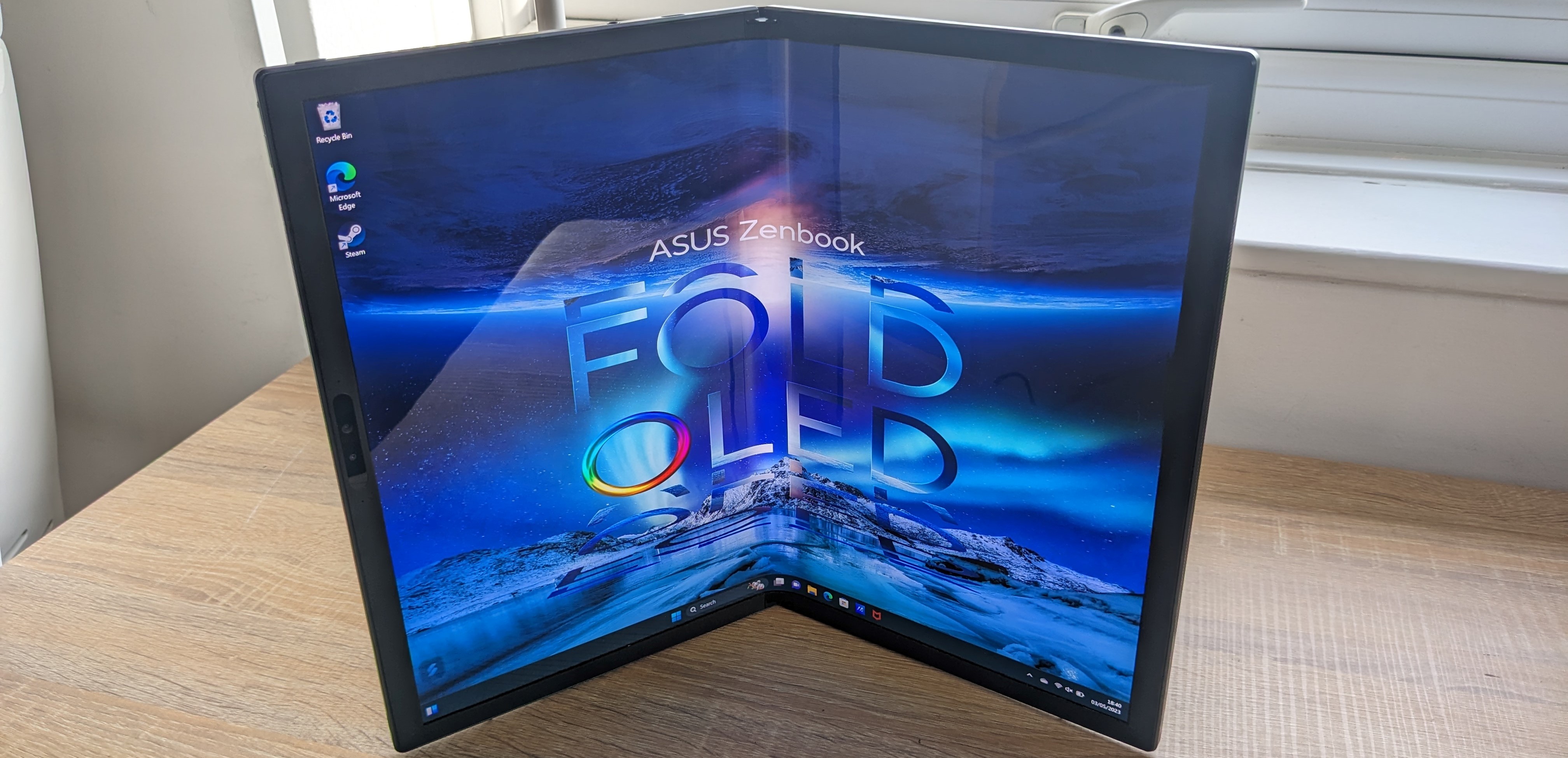 The Asus Zenbook 17 Fold OLED pictured on a wooden desk.