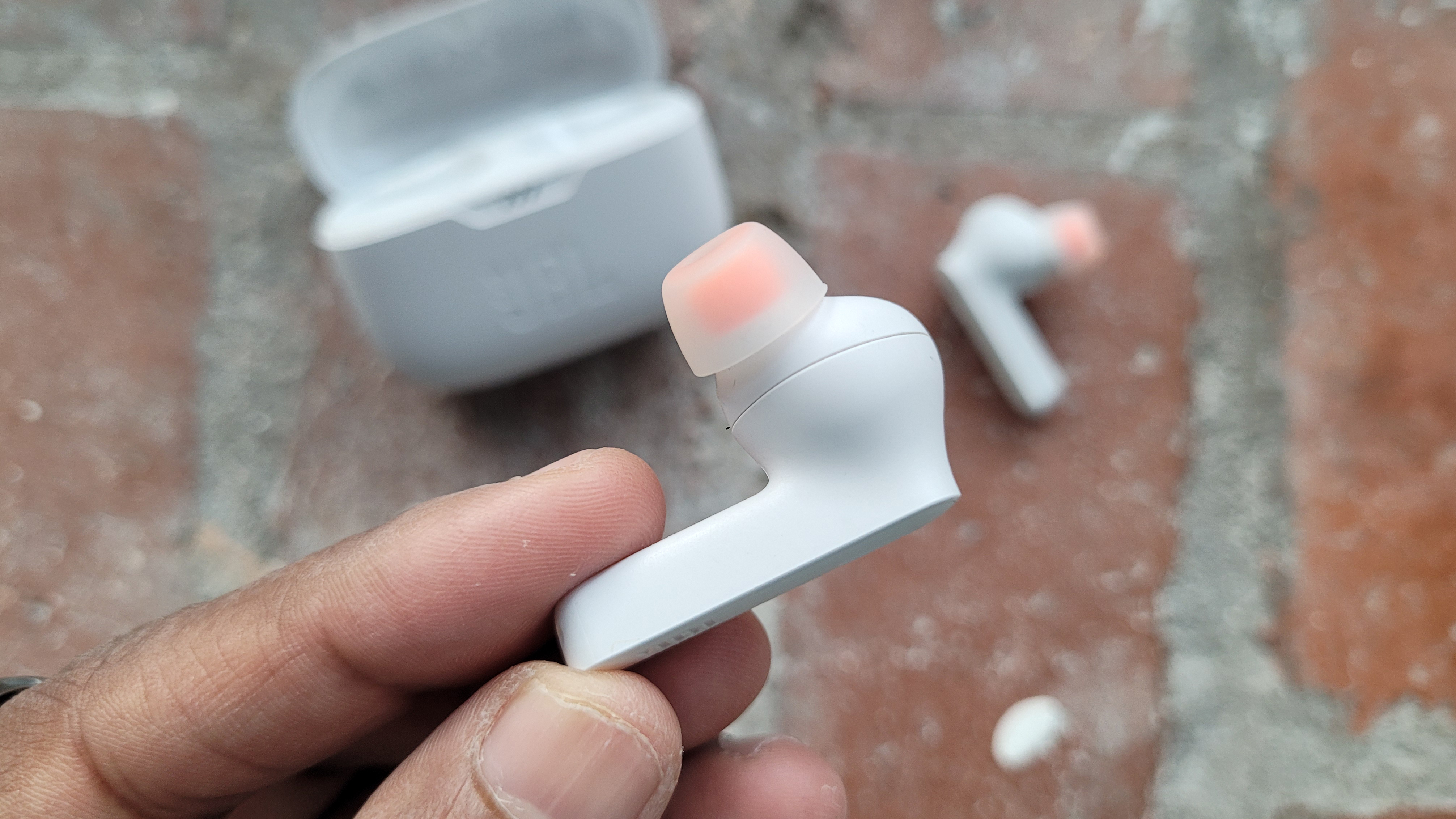 a closeup of one jbl tun 230nc true wireless earbud