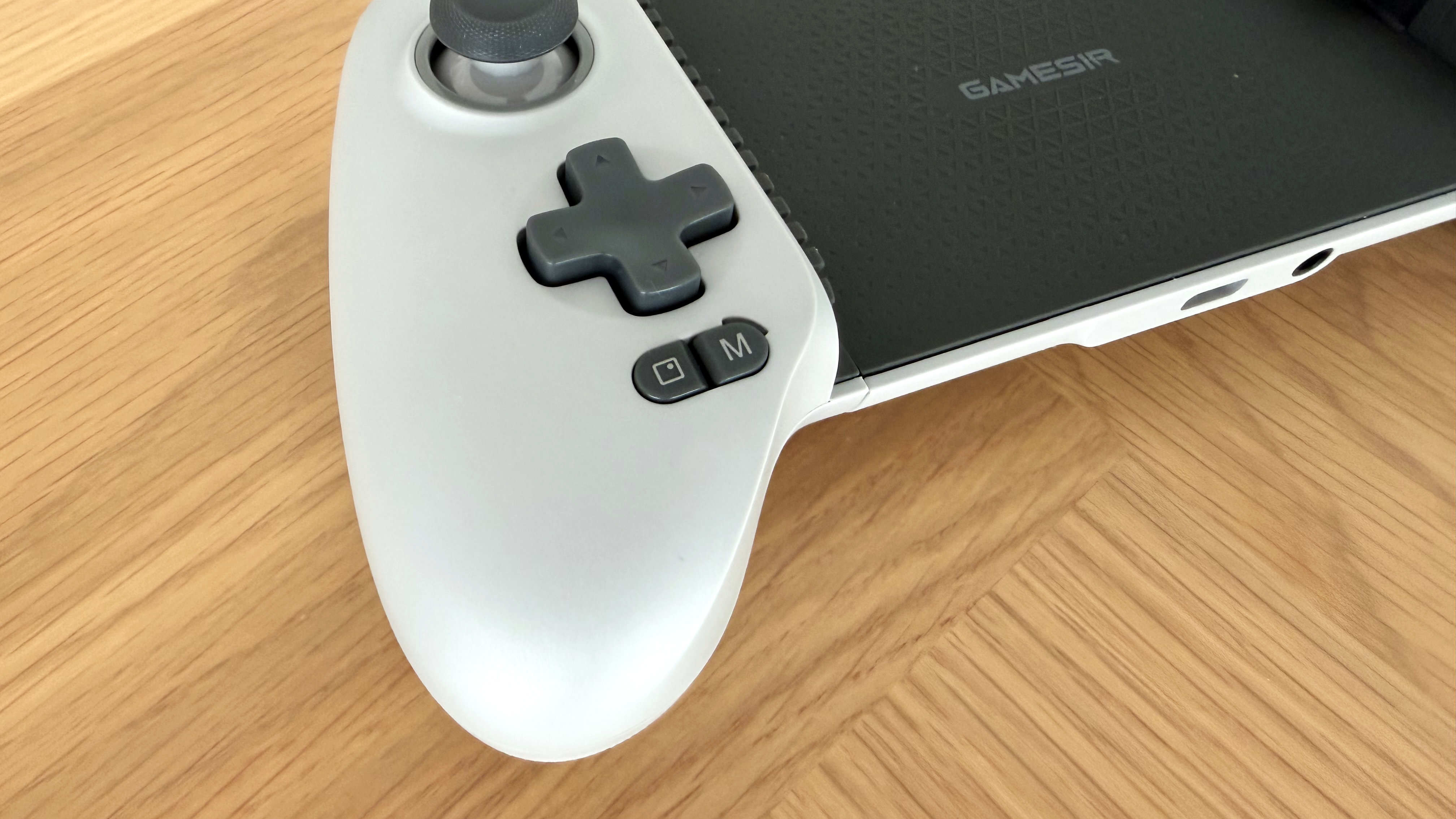 The GameSir G8 Galileo mobile gaming controller on a wooden surface.