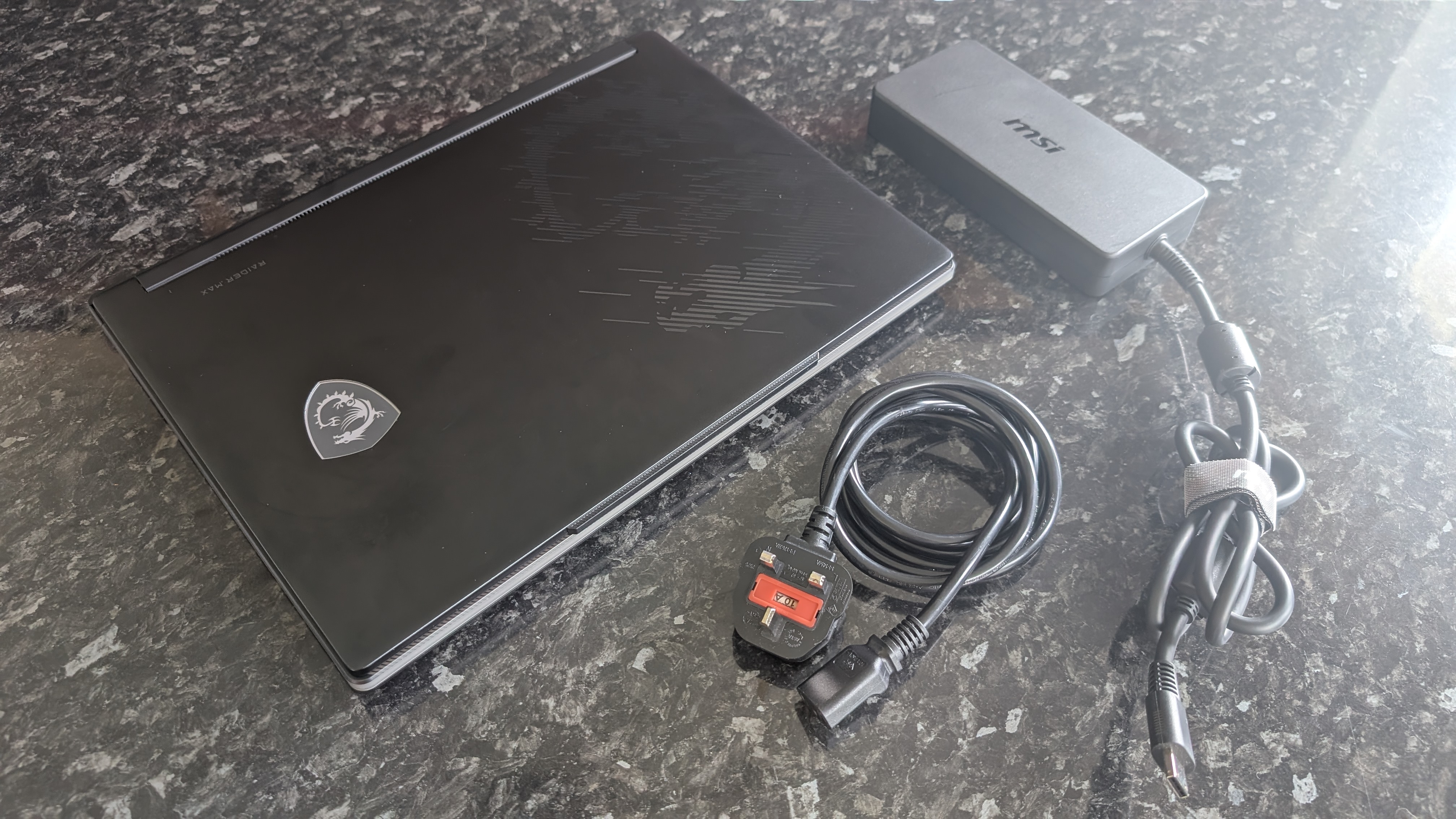 The MSI Raider 16 Max HX gaming laptop pictured on a black marble worktop.