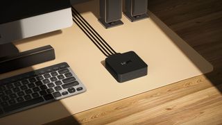 WiiM Pro steamer on wooden desk with compter keyboard and speakers
