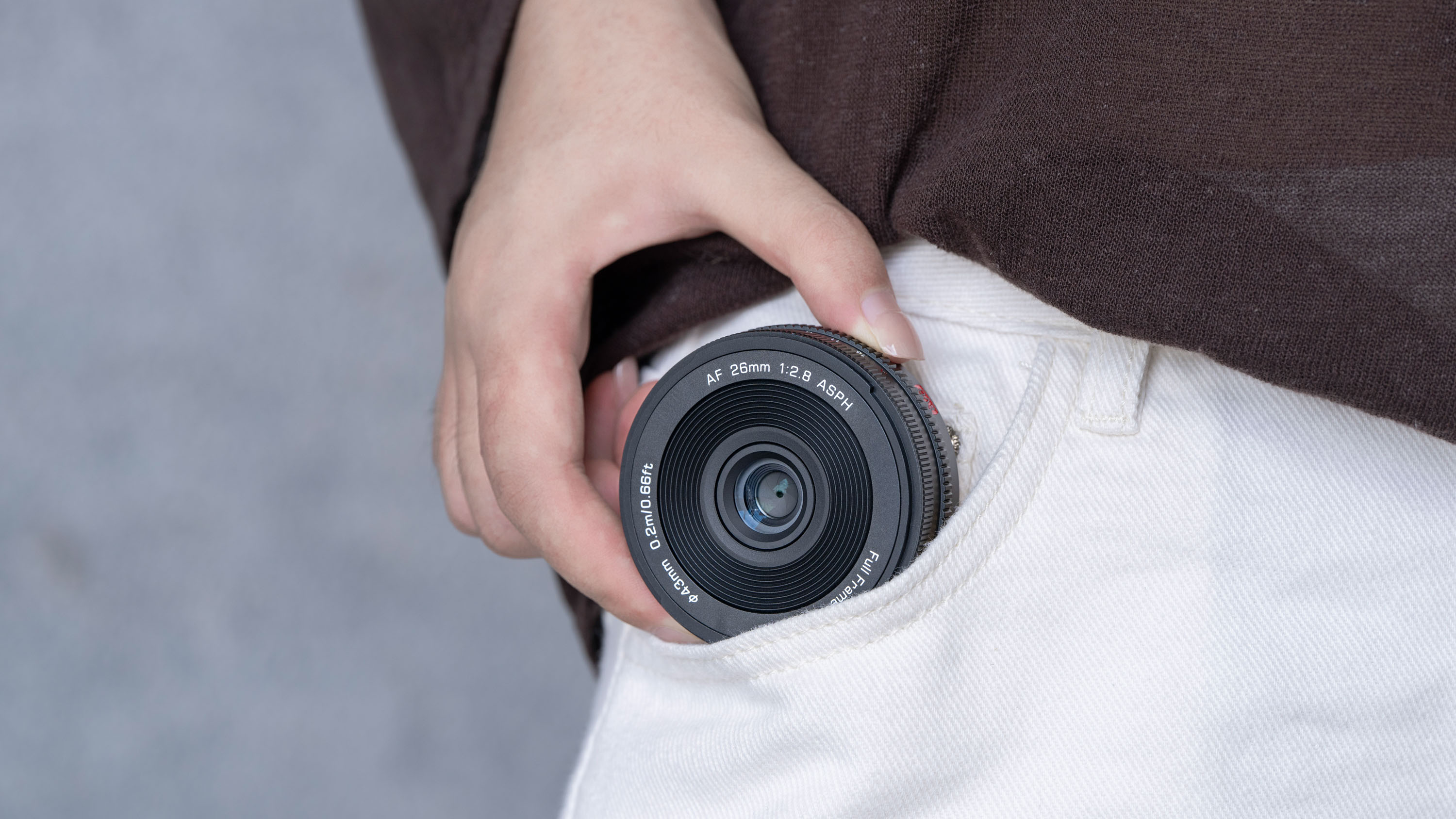 Viltrox AF 26mm F2.8 EVO lens attached to a Sony camera, person is putting it into their pant pocket