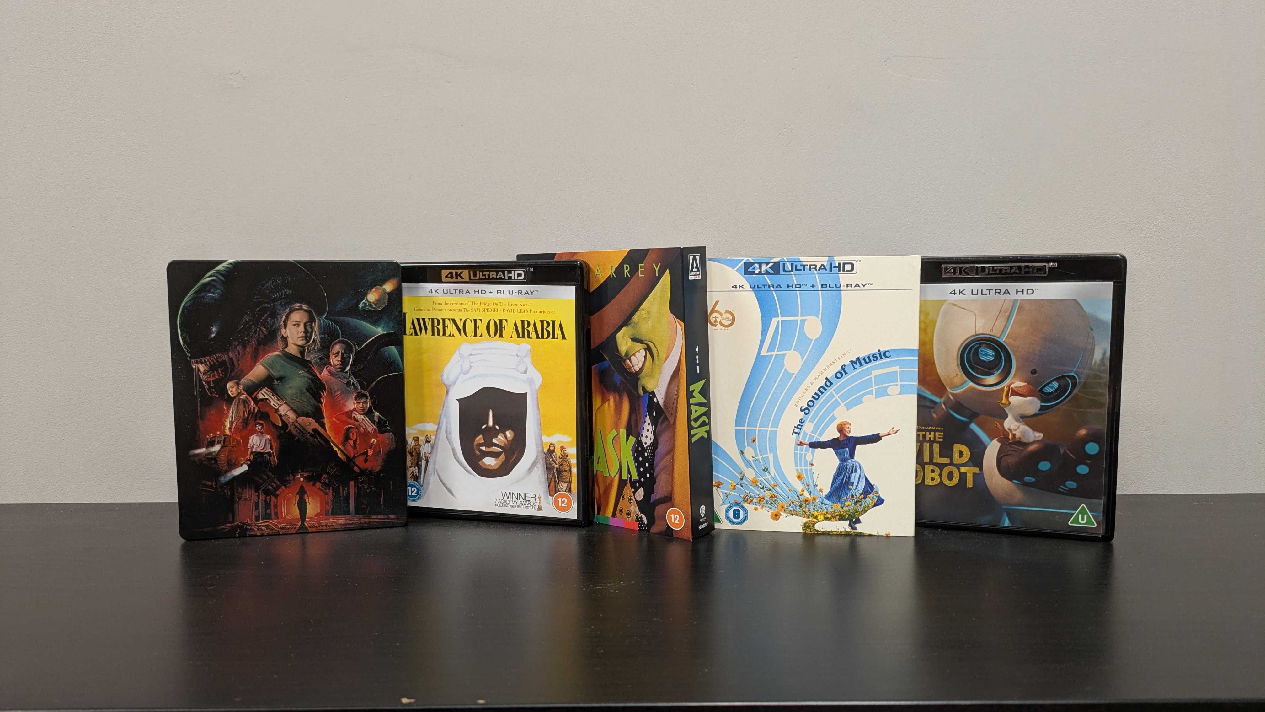 best of blu-ray bounty hero image showing alien romulus, lawrence of arabia, the mask, the sound of music and the wild robot 4K Blu-ray cases in a line 
