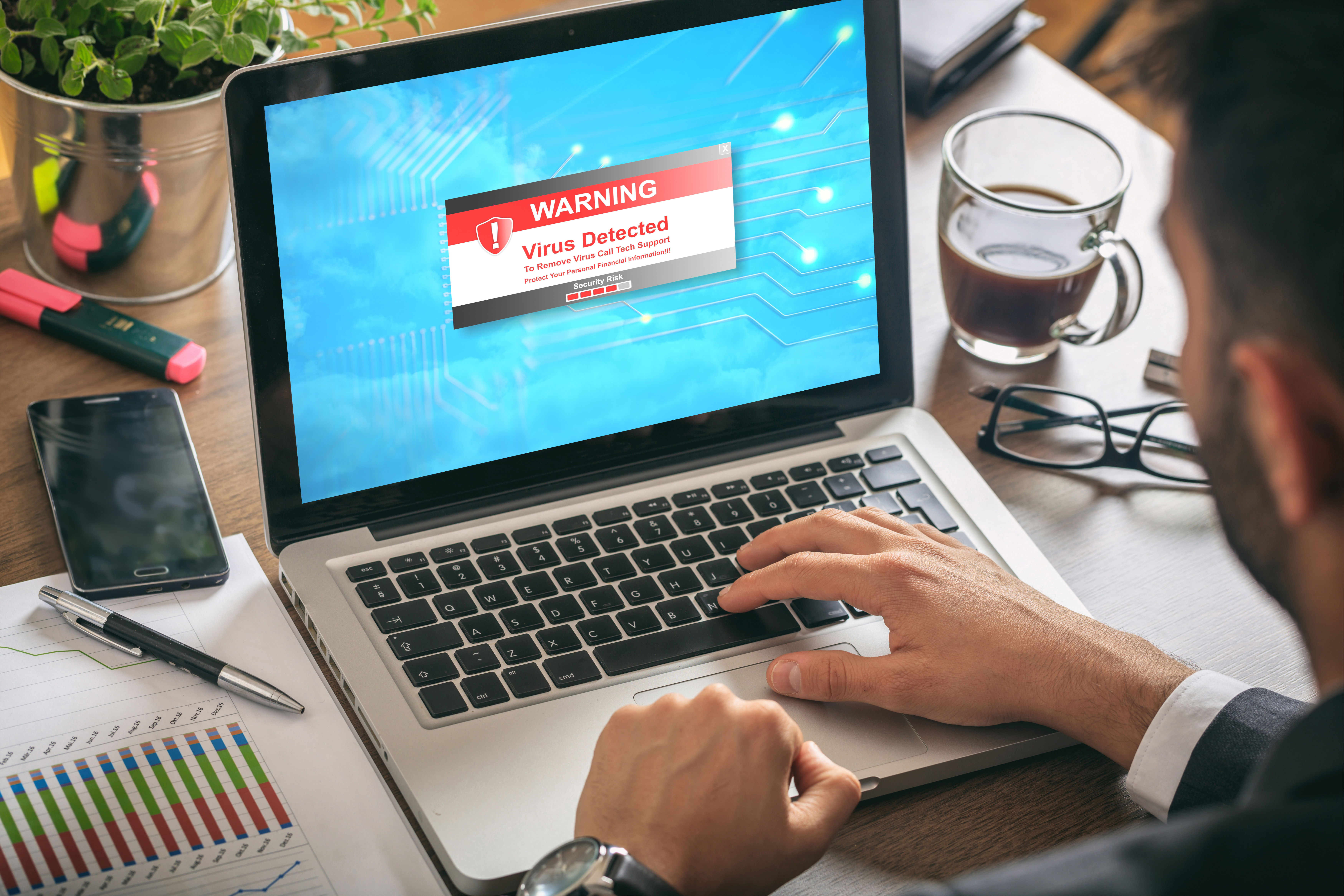 A laptop showing a virus on the screen