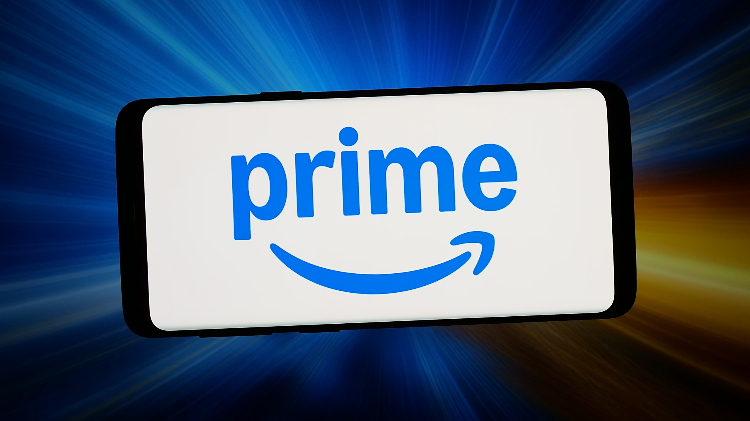 The logo of e-commerce subscription service Amazon Prime is seen displayed on a smartphone in front of an abstract background