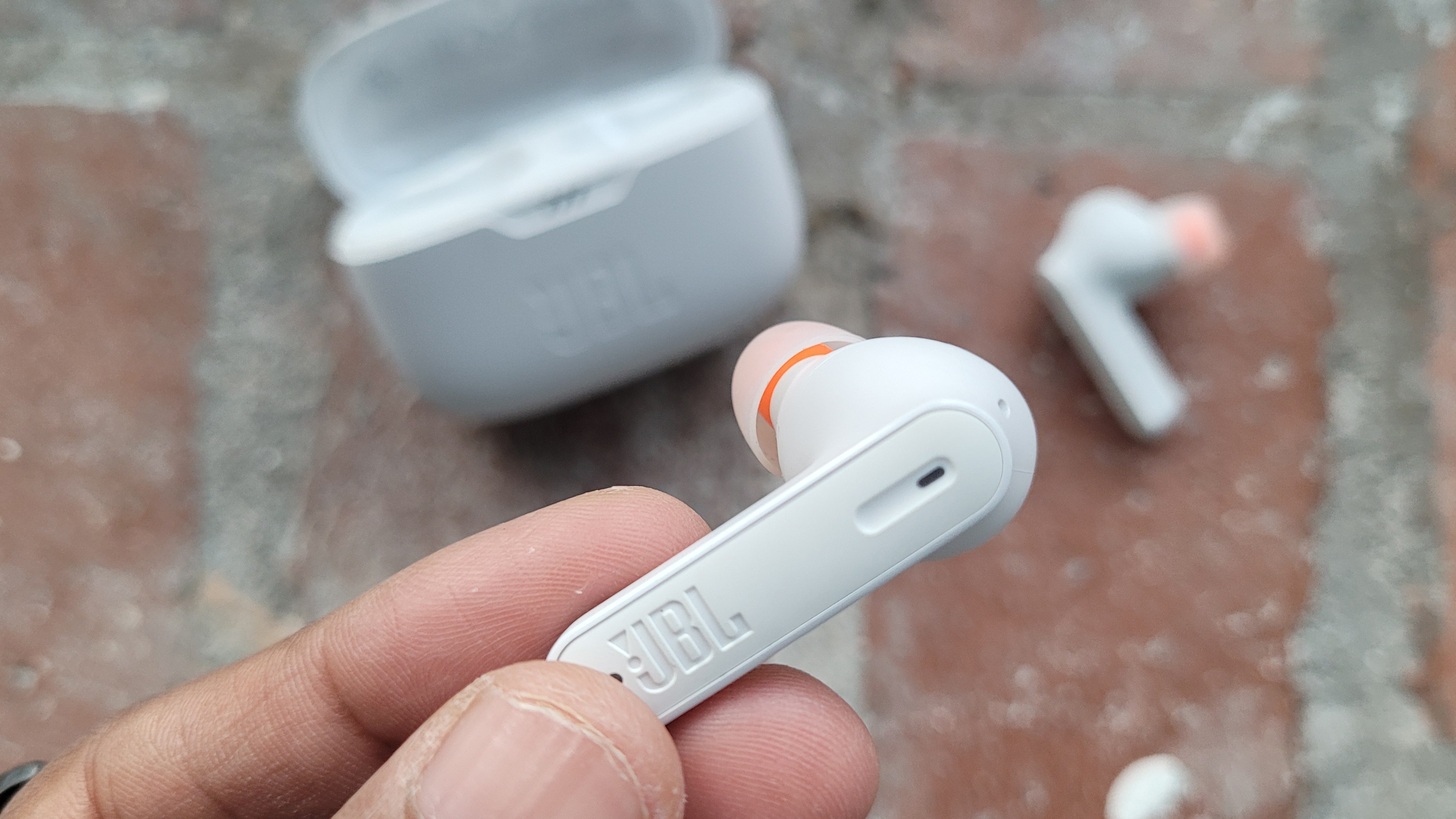 a closeup of one jbl tune 230nc earbud