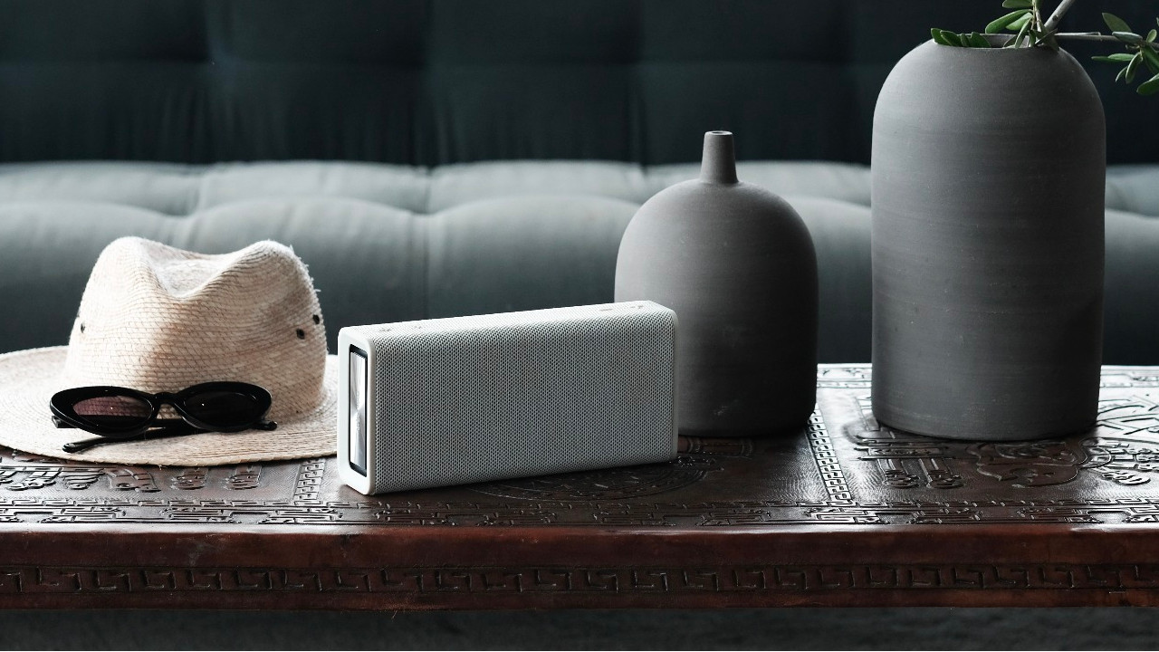 the urbanista brisbane bluetooth speaker on a coffee table
