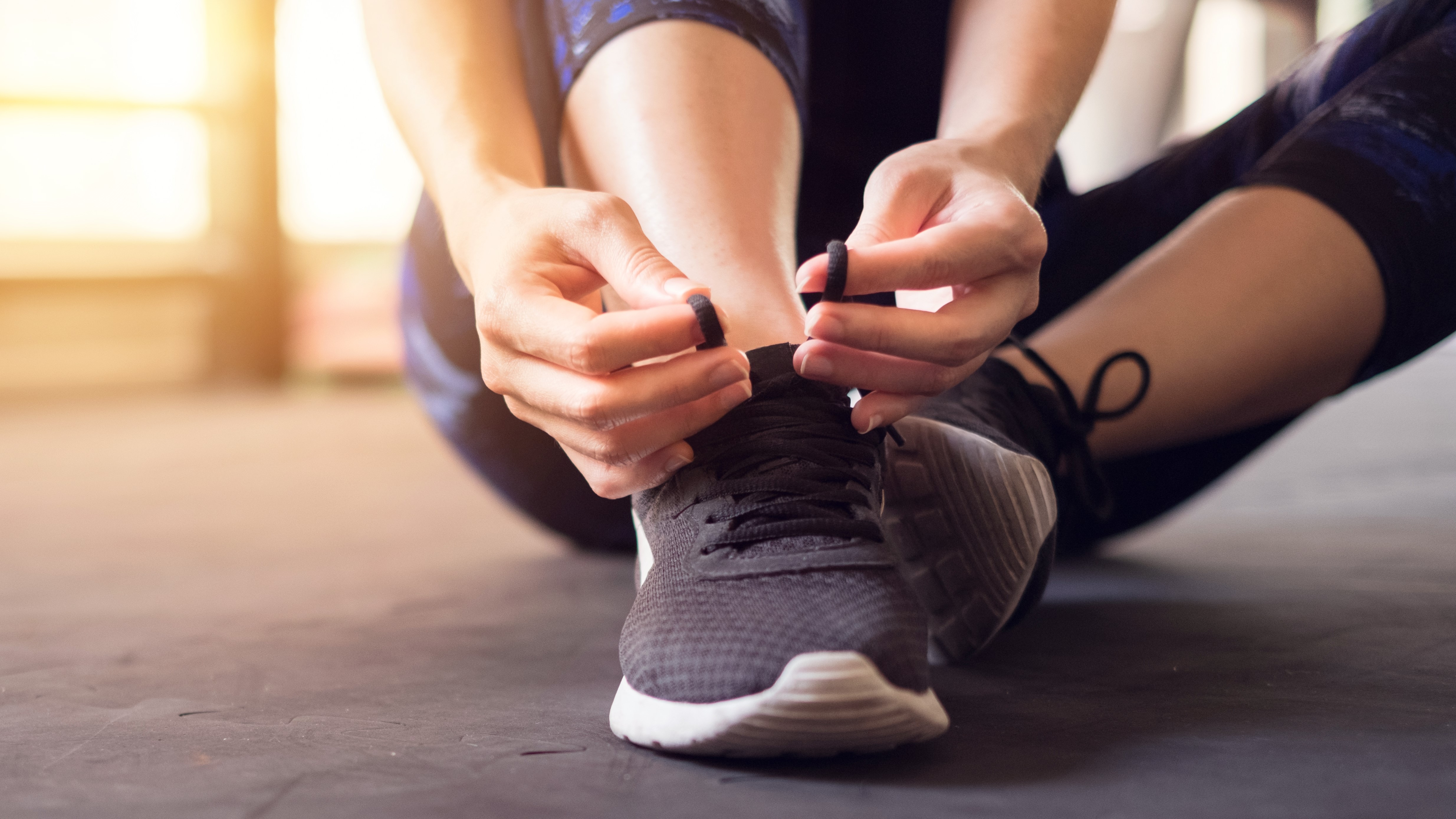 Woman fastening running shoes, not wearing a watch