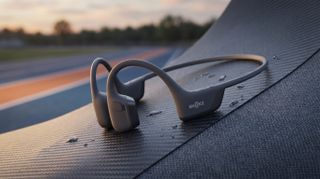The Shokz OpenRun Pro 2 in the foreground with an athletics track in the background.
