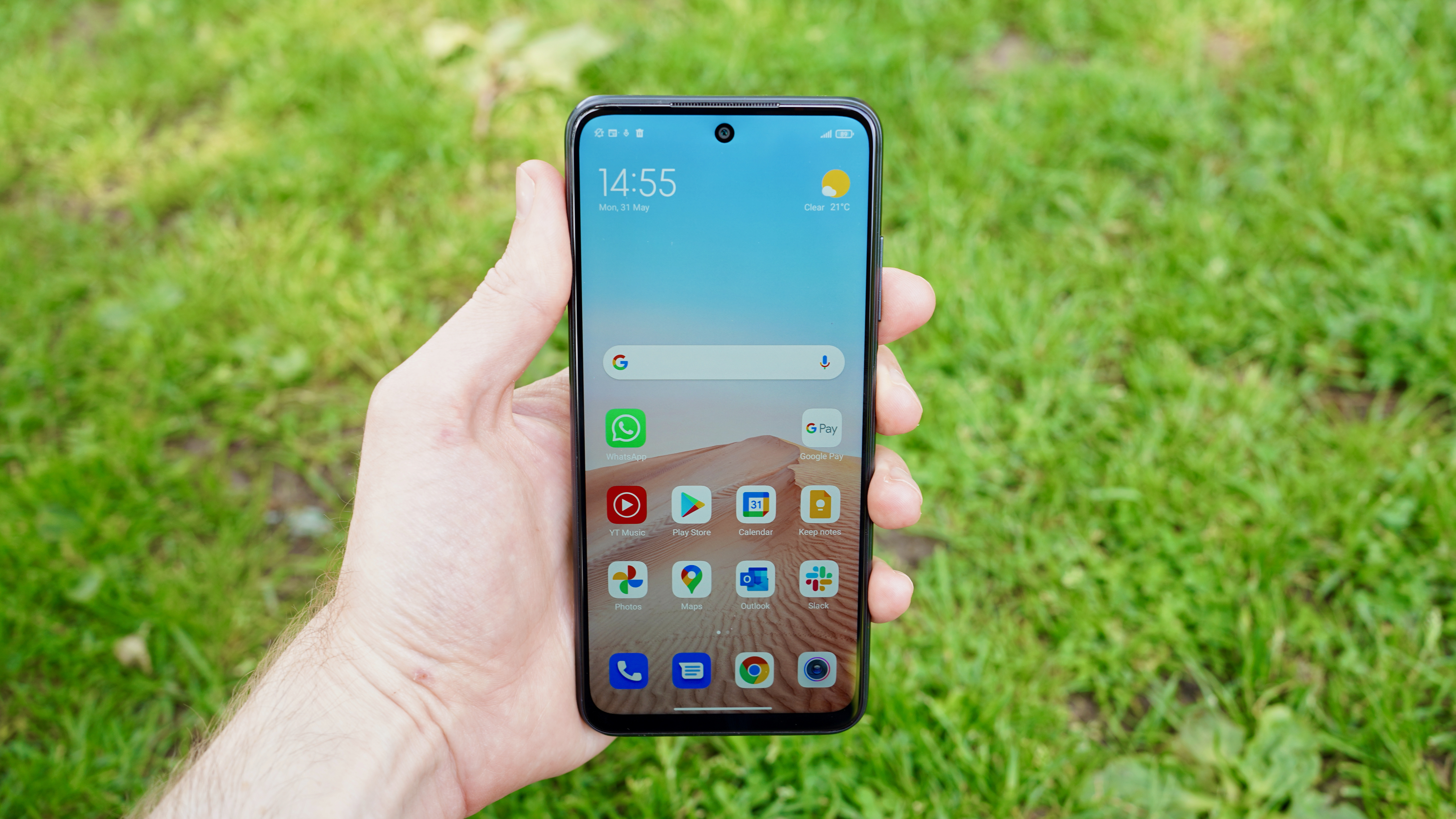 A Xiaomi Redmi Note 10 5G in someone's hand, with the screen on