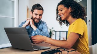 two people posing with a black chromebook