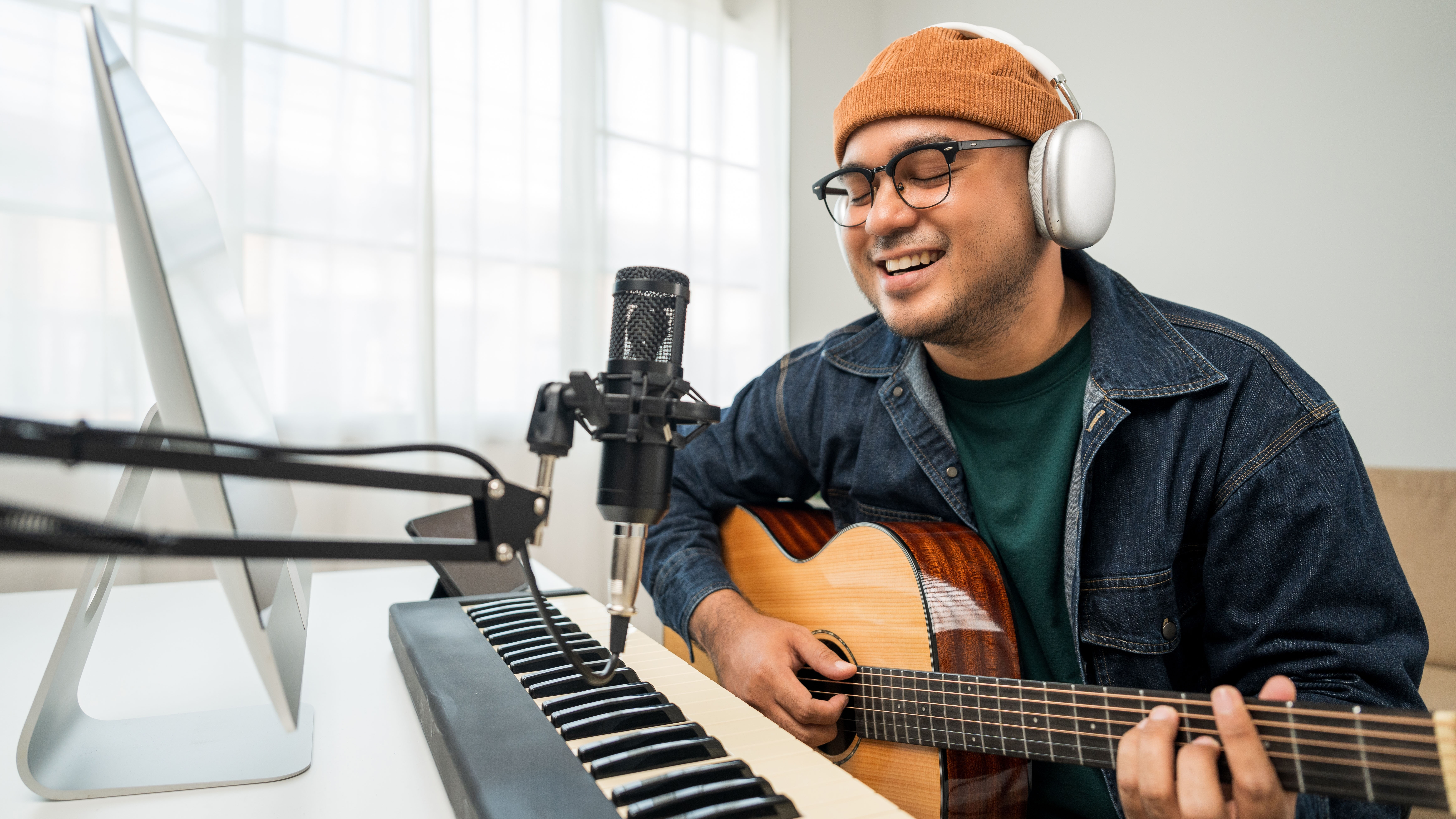 Musician recording with a guitar and keyboard.