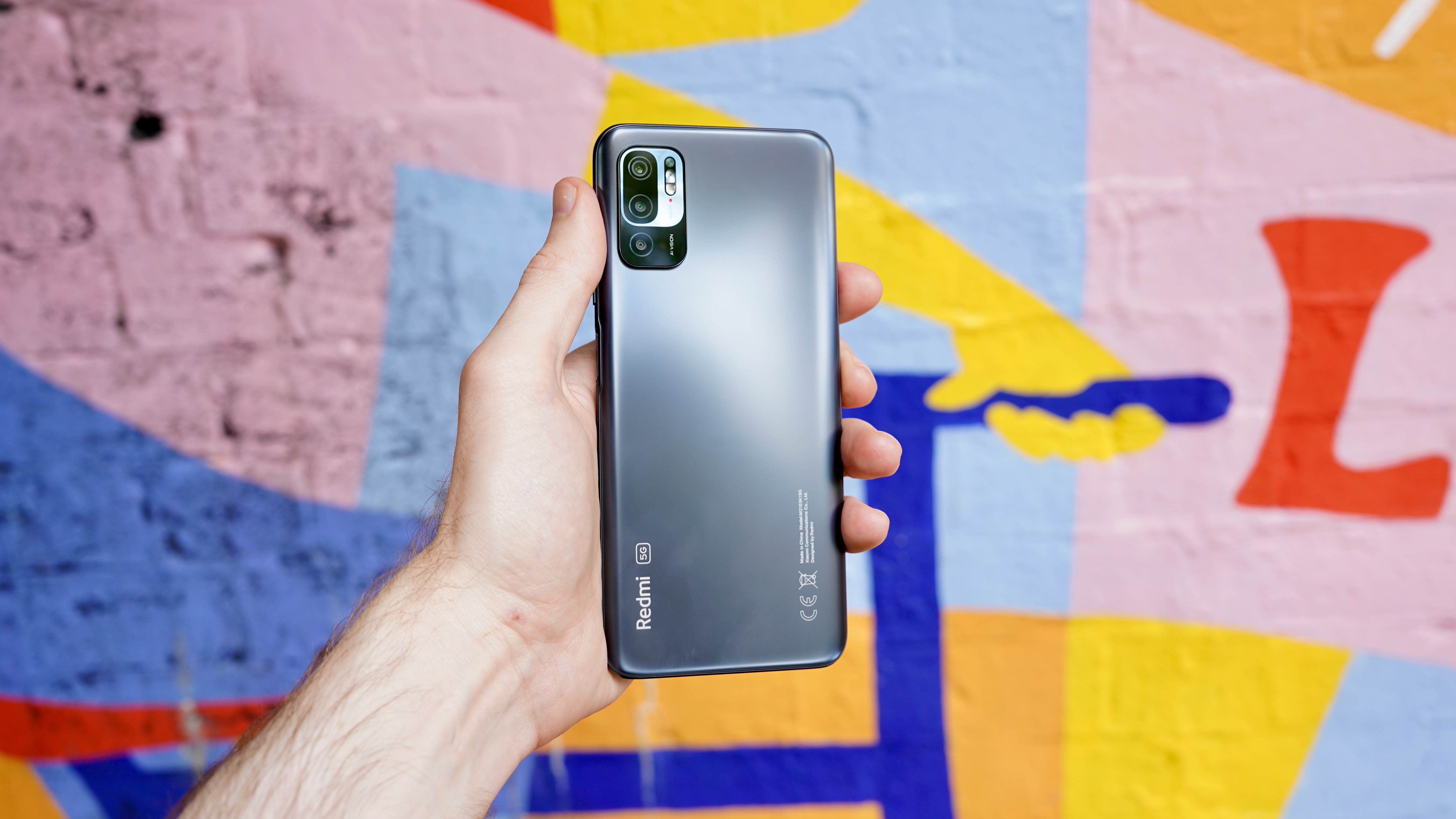 A Xiaomi Redmi Note 10 5G in someone's hand, from the back