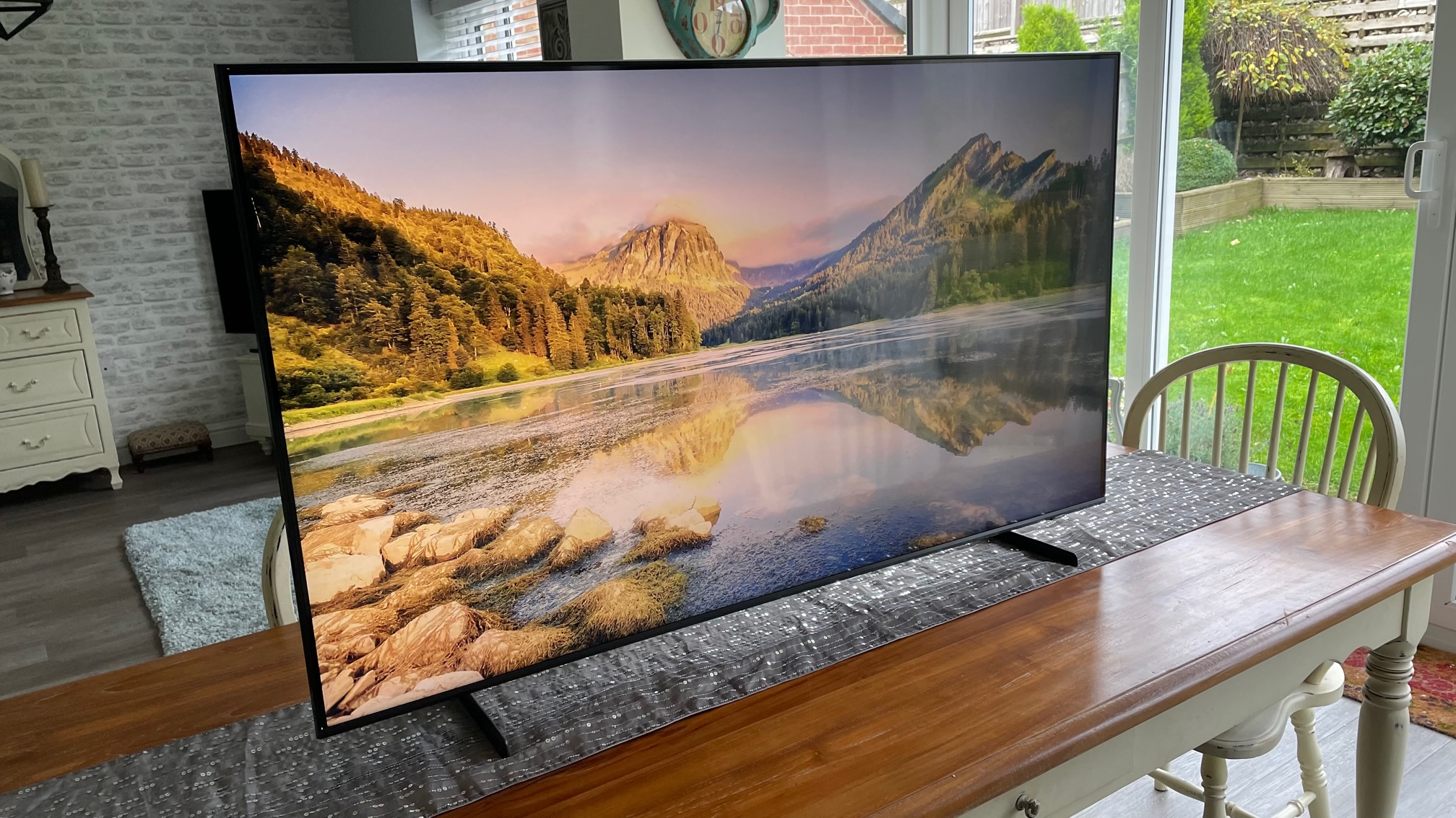 The Samsung QE55Q60B TV pictured in a living room displaying a mountain scene.