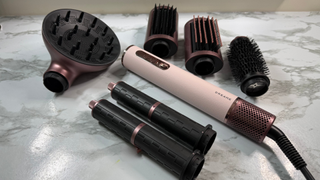 Dreame AirStyle Era multi-styler displayed with diffuser, styling brushes, curling barrels and straightening nozzle attachments