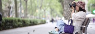 Woman sitting on a bench using an MPB camera