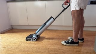 Roborock F25 Ace wet-dry vacuum being used in a kitchen.