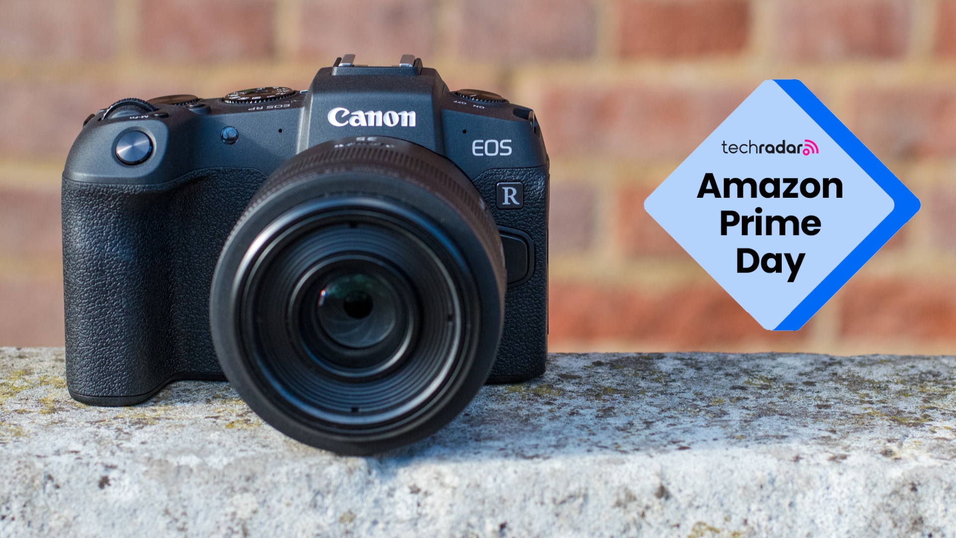 Photograph of the Canon EOS RP sitting on a stone wall, with TechRadar 'Amazon Prime Day' graphic beside it