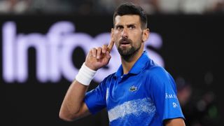Novak Djokovic makes a 'listen' gesture by his ear during an Australian Open 2025 match